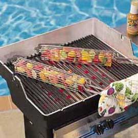 Two kabob baskets filled with chopped meat and vegetables, cooking on a grill